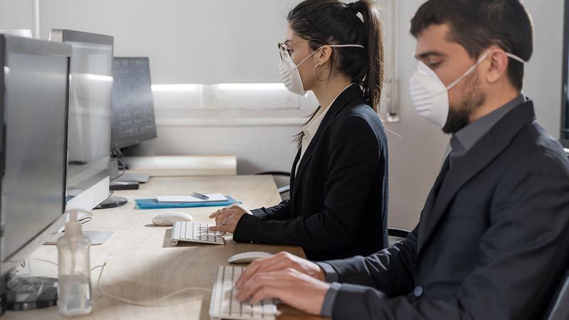 Lavoratori in ufficio con mascherina per tutela COVID 19